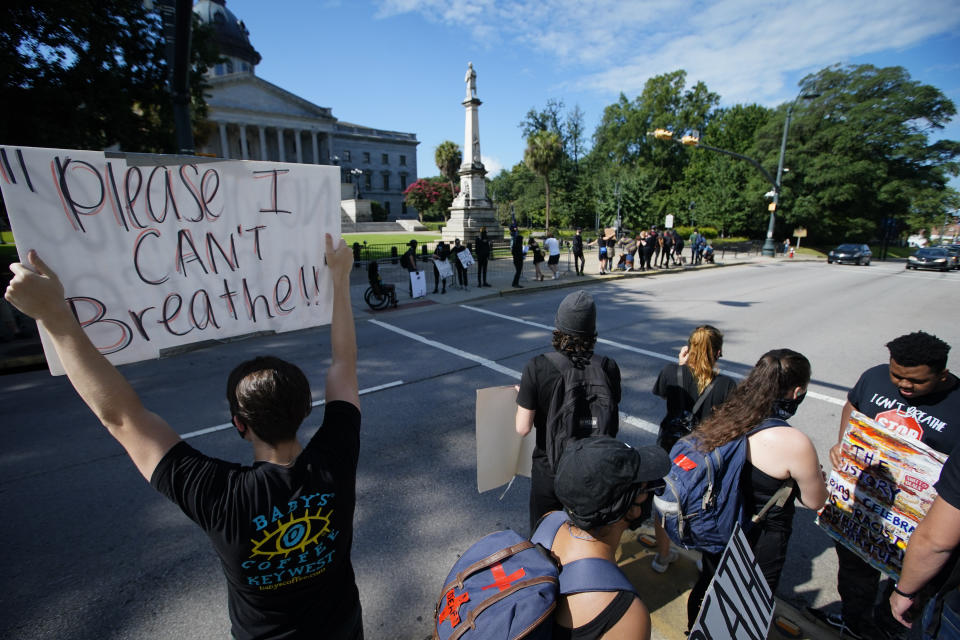 Demonstrators protest in front of a confederate statue at the State House on Friday, July 10, 2020, in Columbia, S.C. Demonstrators on both sides gathered for the five year anniversary after the Confederate battle flag was removed from the State House grounds after a two-thirds vote by the Legislature. (AP Photo/Chris Carlson)