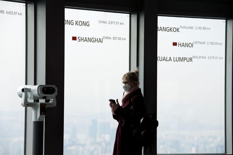 A woman wearing a mask to prevent contracting a new coronavirus looks on at an observation platform at "N Seoul Tower" in Seoul