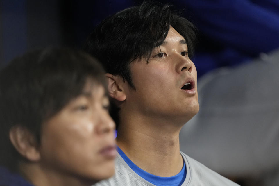 Los Angeles Dodgers designated hitter Shohei Ohtani, right, and his interpreter Ippei Mizuhara sit in the dugout during an opening day baseball game against the San Diego Padres at the Gocheok Sky Dome in Seoul, South Korea Wednesday, March 20, 2024. Ohtani’s interpreter and close friend has been fired by the Dodgers following allegations of illegal gambling and theft from the Japanese baseball star. (AP Photo/Lee Jin-man)