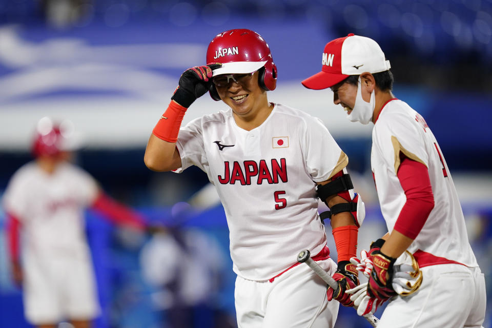 Japan's Yu Yamamoto, center and Yuka Ichiguchi celebrate after Yamamoto's two-run home run during a softball game against Italy at Yokohama Baseball Stadium during the 2020 Summer Olympics, Saturday, July 24, 2021, in Yokohama, Japan. (AP Photo/Matt Slocum)