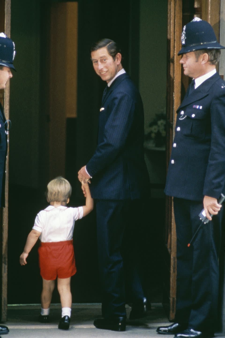 <p>Charles holds Prince William's hand as they arrive at St. Mary's Hospital to visit Princess Diana and newborn Prince Harry. </p>