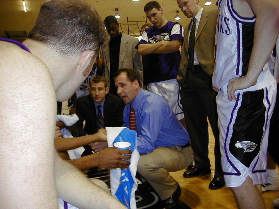 Nate Oats (in background, with suit coat) is shown during a time-out huddle during his time as an assistant coach with UW-Whitewater, a tenure that lasted from 2000-02.