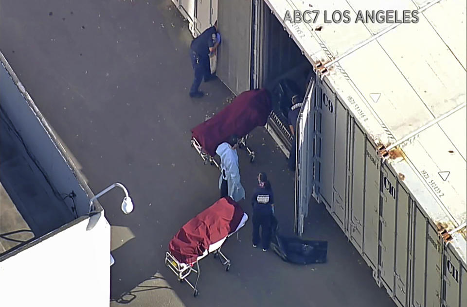 FILE - This file photo from video provided by ABC7 Los Angeles shows workers putting bodies into a refrigerated trailer at the offices of the Los Angeles County Coroner in Los Angeles. More than 500 people are dying each day in California because of the coronavirus. The death toll has prompted state officials to send more refrigerated trailers to local governments to act as makeshift morgues. State officials said Friday they have helped distribute 98 refrigerated trailers to help county coroners store dead bodies. (ABC7 Los Angeles via AP, File)