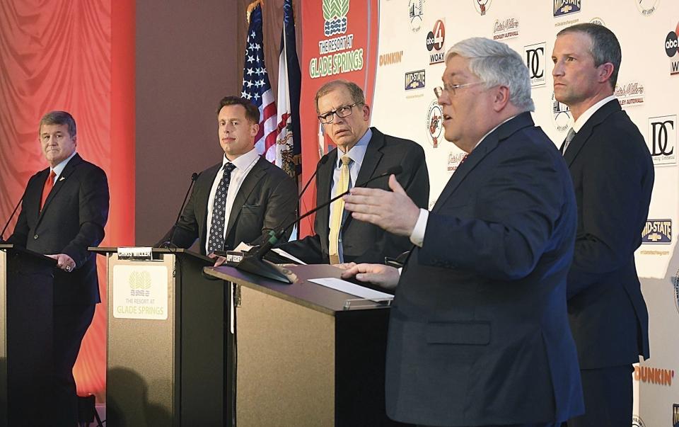 FILE - Attorney General Patrick Morrisey, in foreground, speaks as West Virginia gubernatorial candidates, from left, Mac Warner, Chris Miller, moderator and MetroNews Radio host Hoppy Kercheval and Moore Capito participate in a GOP debate held at The Resort at Glade Springs, Feb. 6, 2024, in Daniels, W.Va. When West Virginia Republicans vote in the primary on Tuesday, May 14, they will have a hard time finding a major candidate on the ballot in any statewide race who openly acknowledges that President Joe Biden won the 2020 election. (Rick Barbero/The Register-Herald via AP, File)