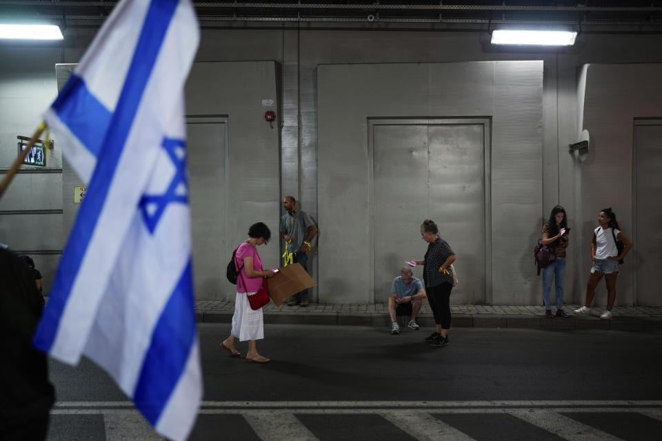 Israelis take cover in an underground car tunnel as a siren warns of incoming rockets fired from the Gaza Strip, during a protest calling for the return of more than 220 people captured by Hamas militants, in Tel Aviv, Israel, Saturday, Oct. 28, 2023. (AP Photo/Bernat Armangue)