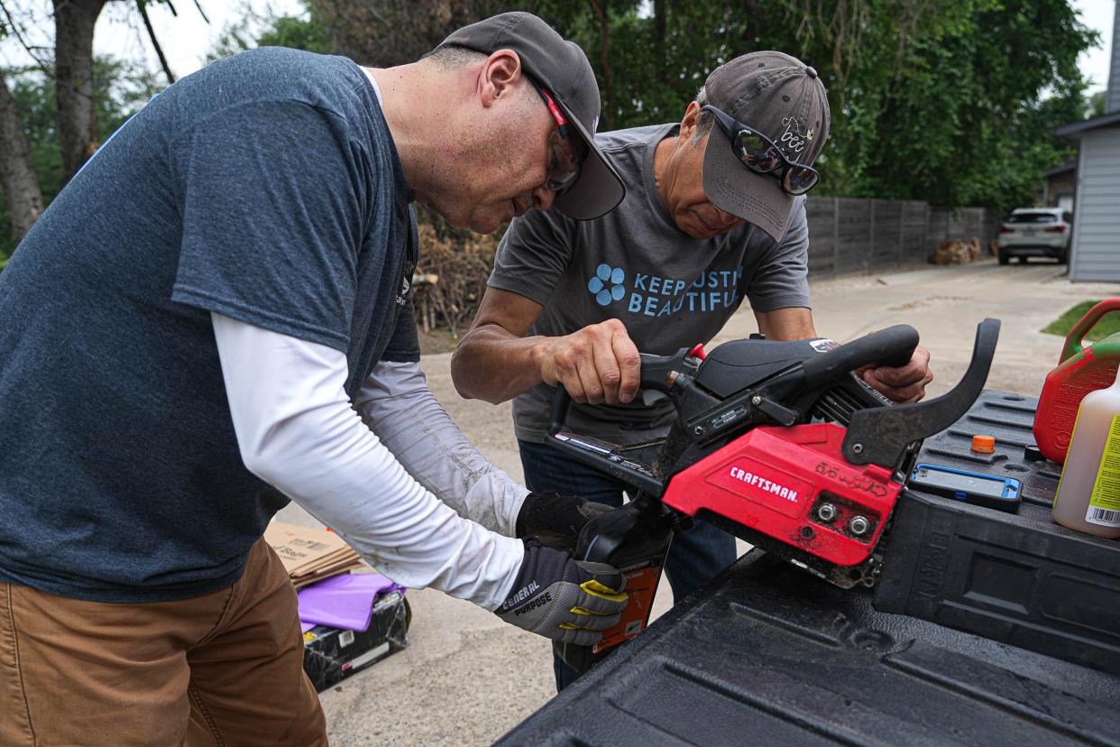 Joaquin Rodriguez, president of the San Jose Montopolis Cemetery Assiciation, right, and Jesse Cabrera, left, change the oil in a chainsaw during a community cleanup day at San Jose Cemetery in East Austin on Saturday, April 20, 2024.