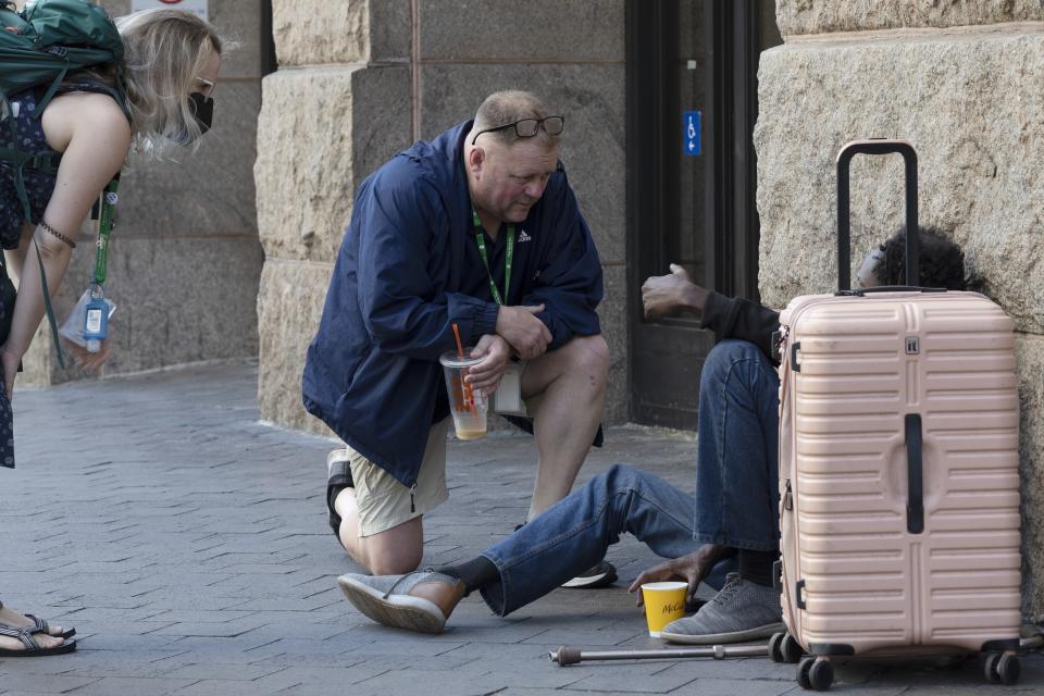 FILE - Pine Street Inn's Director of Outreach Michael Andrick, center, and Kyra Boyer, left, a clinical supervisor on the behavioral health outreach team, talk with a homeless man, Thursday, Aug. 25, 2022, in Boston. President Joe Biden's Administration announced Monday, Dec. 19 it is ramping up efforts to help house people now sleeping on sidewalks, in tents and cars as a new federal report confirms what's obvious to people in many cities: Homelessness is persisting despite increased local efforts. (AP Photo/Michael Dwyer, File)