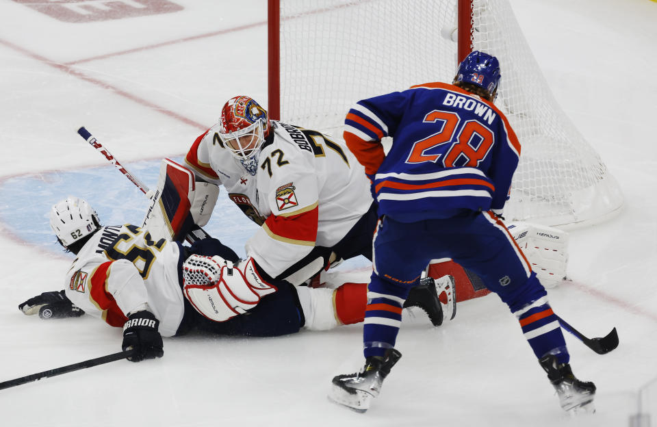 Edmonton Oilers' Connor Brown (28) works to get the puck around Florida Panthers goaltender Sergei Bobrovsky (72) and Brandon Montour (62) during the first period of Game 4 of the NHL hockey Stanley Cup Final, Saturday, June 15, 2024, in Edmonton, Alberta. (Jeff McIntosh/The Canadian Press via AP)