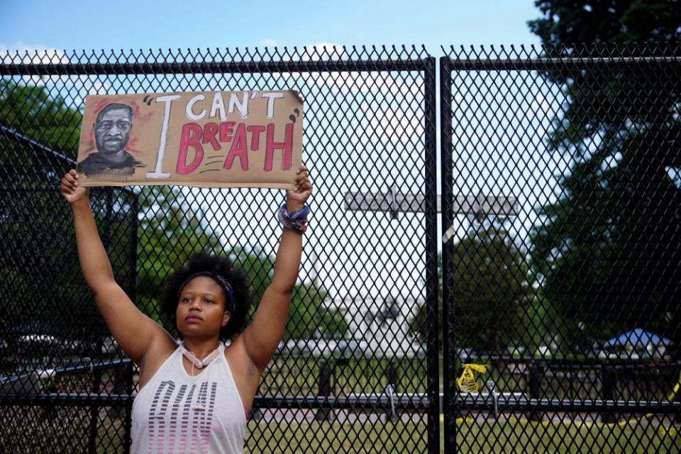 A woman in Washington on Friday holds a placard demanding justice for George Floyd.
