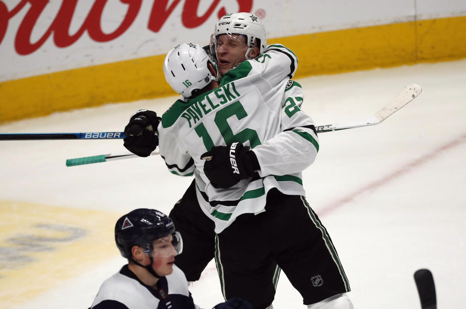 Dallas Stars center Joe Pavelski, front, hugs defenseman Esa Lindell after he scored the winning goal in overtime of an NHL hockey game against the Colorado Avalanche Tuesday, Jan. 14, 2020, in Denver. Dallas won 3-2 in overtime. (AP Photo/David Zalubowski)