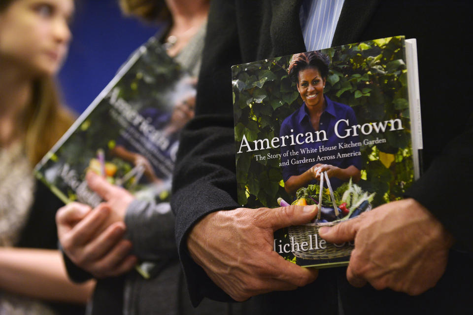 People wait in a line with their copies of US First Lady Michelle Obama's book 'American Grown: The Story of the White House Kitchen Garden and Gardens Across America,' to get them autographed at Politics & Prose in Washington, DC, on May 7, 2013. Photo credit:  JEWEL SAMAD/AFP/Getty Images