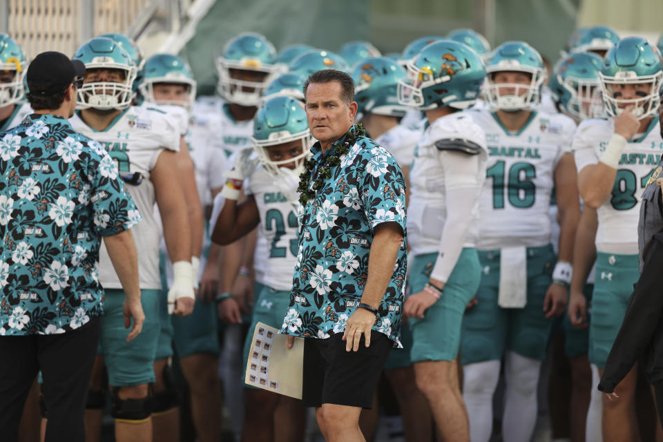 FILE - Coastal Carolina coach Tim Beck, center, stands with the team before the Hawaii Bowl NCAA college football game against San Jose State, Saturday, Dec. 23, 2023, in Honolulu. Coastal Carolina and Delaware will play a home-and-home football series in 2026 and 2029. (AP Photo/Marco Garcia, File)