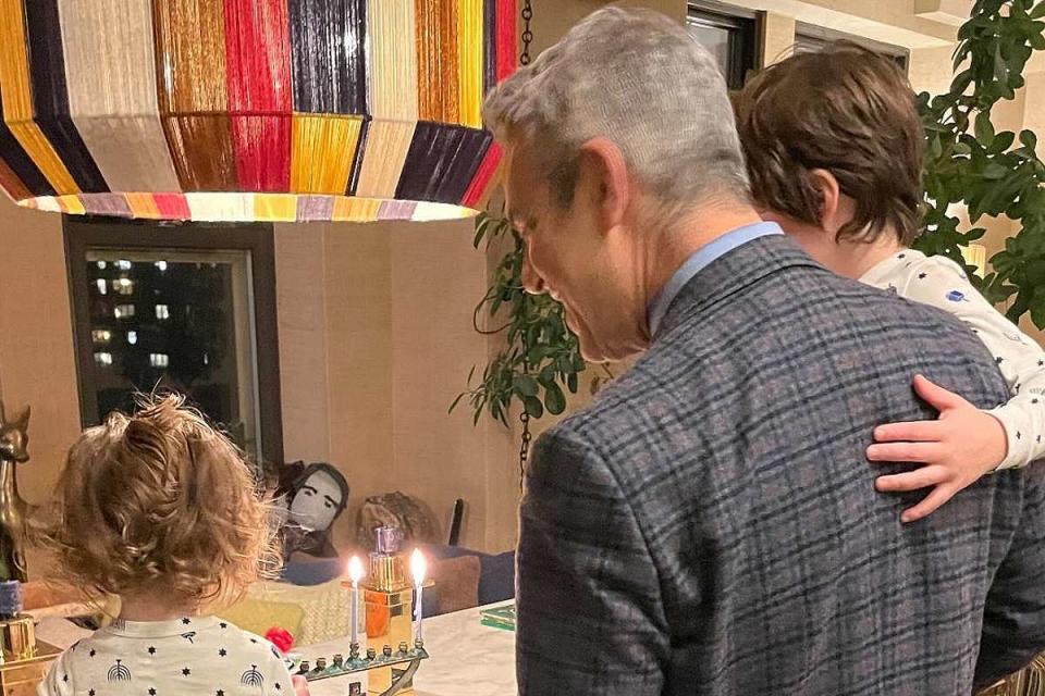 <p>Andy Cohen/Instagram</p> Andy Cohen admires menorah with daughter Lucy and son Ben