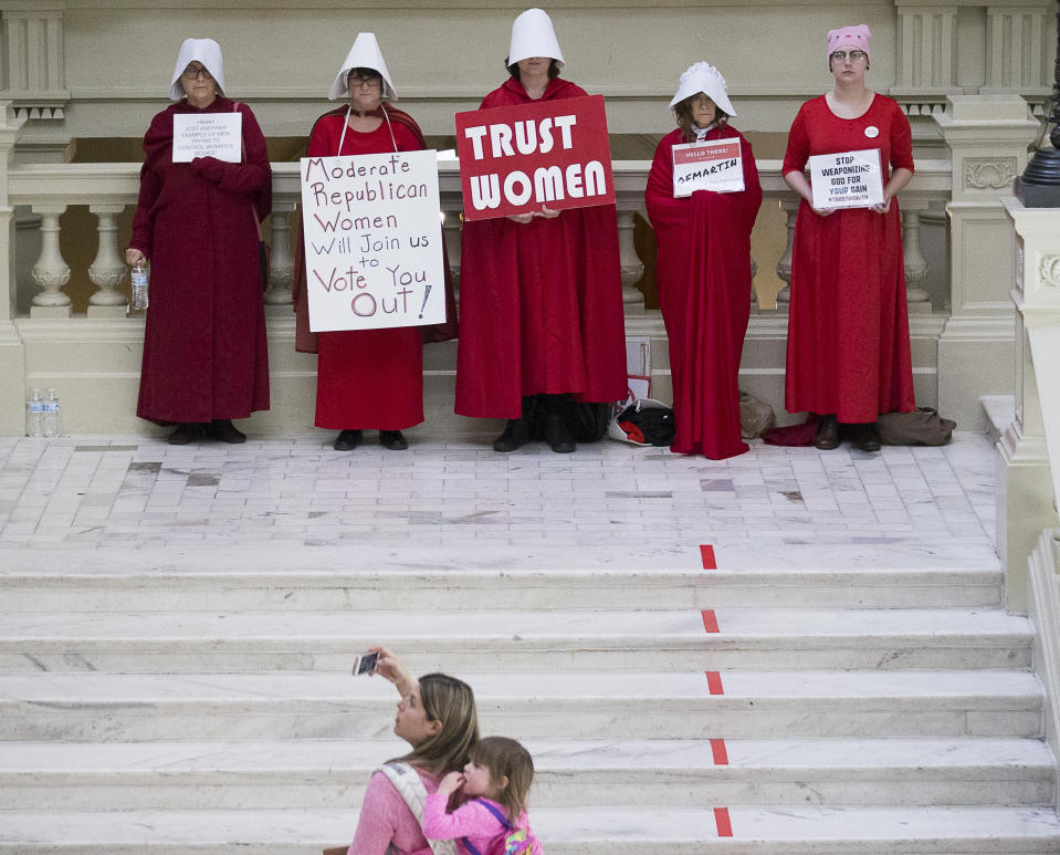 File-This March 22, 2019, file photo shows a woman recording a group of pro-abortion rights demonstrators the 35th legislative day at the Georgia State Capitol building in downtown Atlanta. Bucking intense opposition from abortion rights groups, citizens, physicians groups and even Hollywood celebrities, Georgia lawmakers gave final approval Friday, March 29, 2019, to a "heartbeat" abortion ban that would outlaw almost all abortions in the state. The proposal now heads to the desk of Republican Gov. Brian Kemp, who backs it. If enacted, it would be among the strictest abortion bans in the U.S. (Alyssa Pointer/Atlanta Journal-Constitution via AP, File)