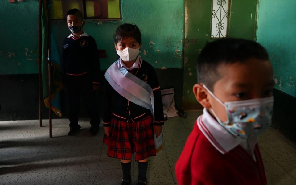School children wearing face masks attend the start of classes ceremony at the Ramona Gil School in Chimaltenango, 60 km west of Guatemala City - JOHAN ORDONEZ/AFP 