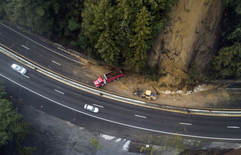 Caltrans crews work to clear a mudslide on Highway 17 that resulted from heavy rain from an atmospheric river storm in the Santa Cruz Mountains, south of Glenwood Drive in Scott's Valley, Calif., on Monday, Jan. 9, 2023. (Carlos Avila Gonzalez/San Francisco Chronicle via AP)