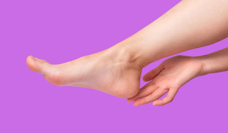 Image of a woman's hand touching her heel