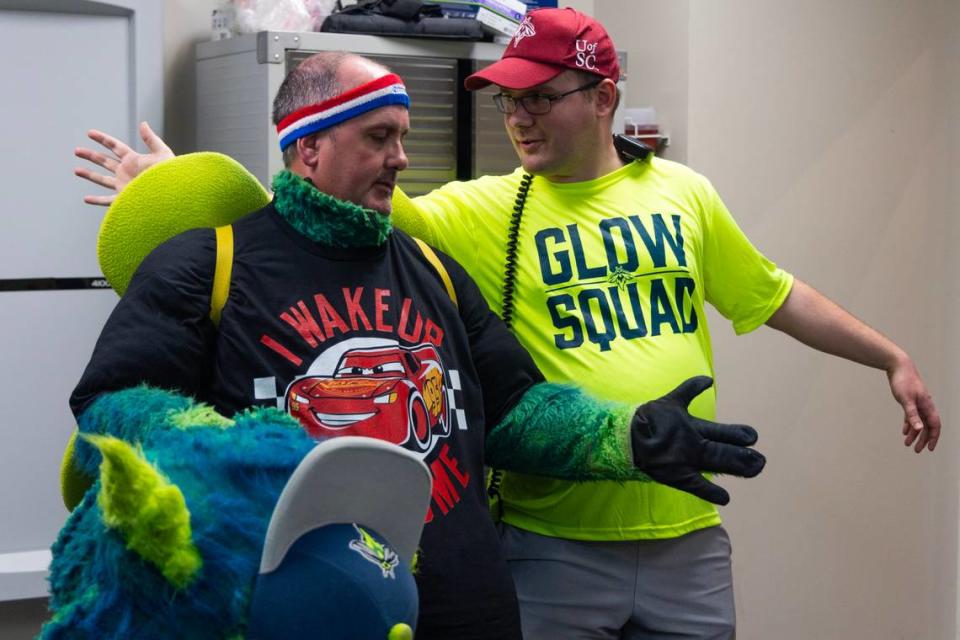 Jacob Strickland, the man behind Mason, the Fireflies mascot, gives advice to The State reporter Chris Trainor, on how to best pose for photographs in the costume at Segra Park as the Fireflies play the Pelicans on Thursday, April 11, 2024. Joshua Boucher/jboucher@thestate.com