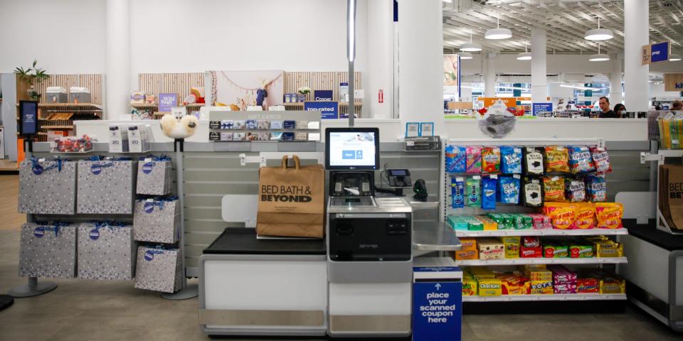 A self checkout station in the store with products next to it