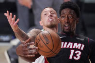 Miami Heat's Bam Adebayo (13) is tied up by Boston Celtics' Daniel Theis, background, during the second half of an NBA conference final playoff basketball game Sunday, Sept. 27, 2020, in Lake Buena Vista, Fla. Adebayo was fouled on the play. (AP Photo/Mark J. Terrill)