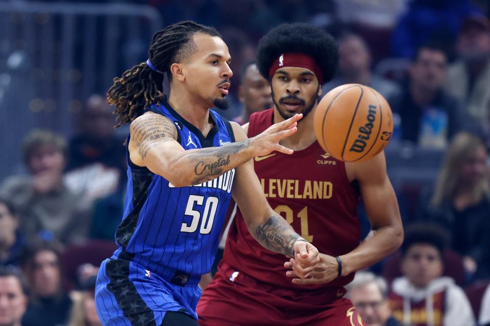 Orlando Magic guard Cole Anthony (50) passes against Cleveland Cavaliers center Jarrett Allen (31) during the first half of a NBA basketball game, Wednesday, Oct. 26, 2022, in Cleveland. (AP Photo/Ron Schwane)