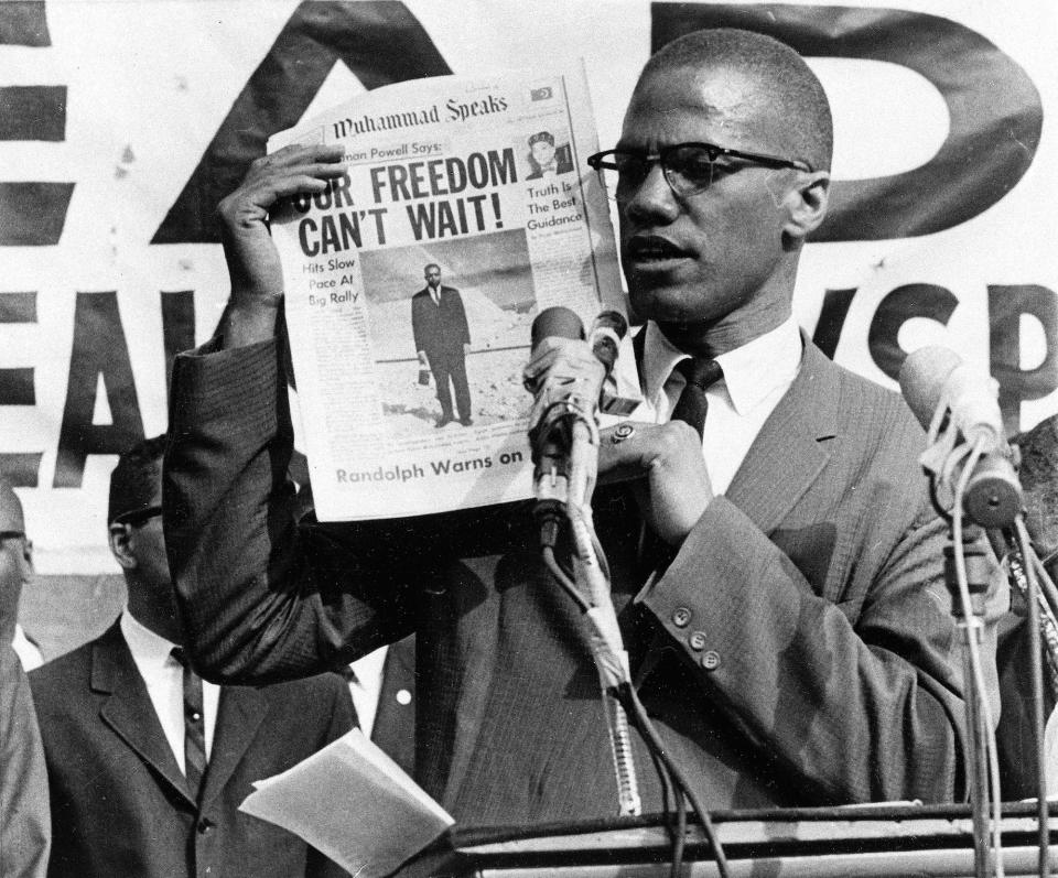 Black Muslim leader Malcolm X holds up a paper for the crowd to see during a Black Muslim rally in New York City on Aug. 6, 1963.