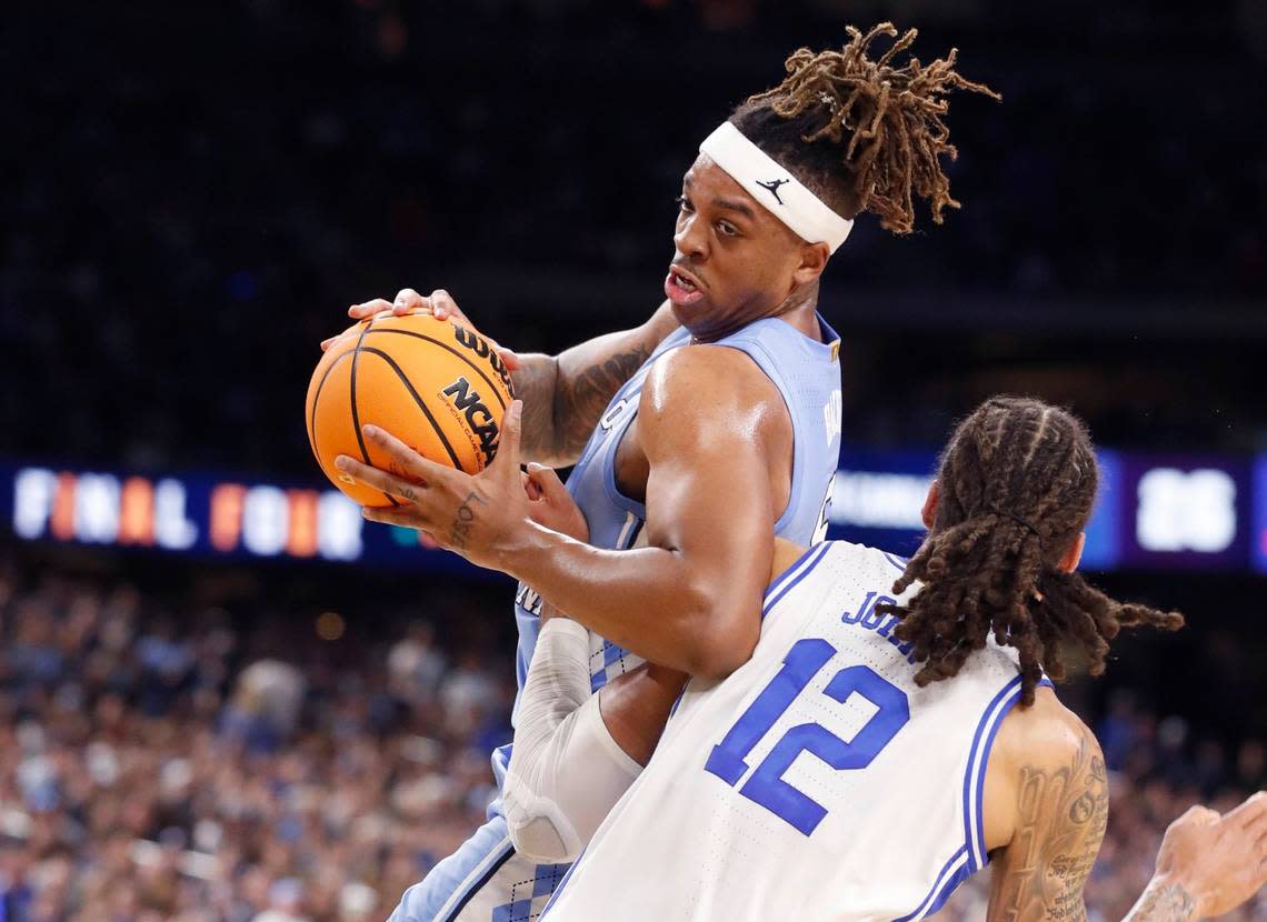 North Carolina’s Armando Bacot (5) drives around Dukes Theo John (12) during the first half of Dukes game against UNC in the Final Four at Caesars Superdome in New Orleans, La., Saturday, April 2, 2022.
