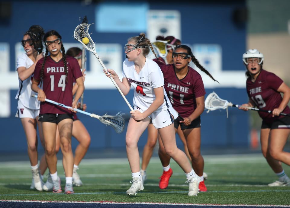 Wappingers' Haley Washall gets the ball under control as Ossining's defense closes in on her during a Section 1 Class A girls lacrosse quarterfinal on May 19, 2023.