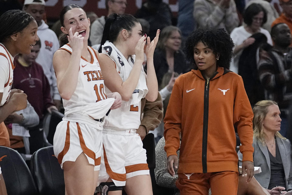 Texas guard Rori Harmon, right, stands with teammates along the bench during the second half of an NCAA college basketball game against Jackson State in Austin, Texas, Wednesday, Dec. 27, 2023. Harmon missed the game due to an injury. (AP Photo/Eric Gay)