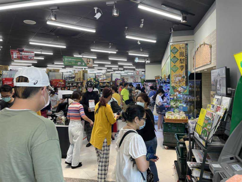 台北、新北市疫情警戒升至三級，大量民眾衝入超商，搶購罐頭、泡麵等物資，賣場人員緊急補貨。（圖／中國時報蔡雯如攝）