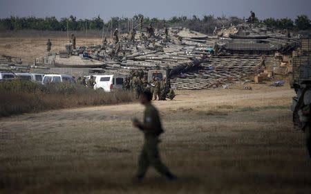 Israeli soldiers gather at a military staging area outside the southern Gaza Strip July 7, 2014. REUTERS/Baz Ratner