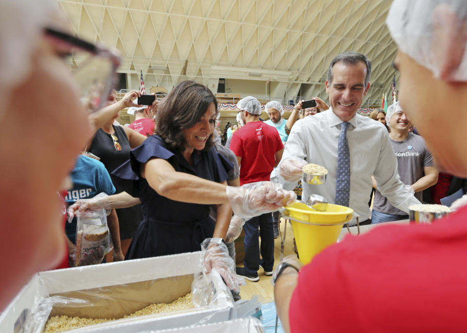 Paris Mayor Anne Hidalgo and Los Angeles Mayor Eric Garcetti help pack lunches for the needy following a ceremony marking the 17th anniversary of the Sept. 11, 2001 terrorist attacks on America, at the Los Angeles Fire Department's training center Tuesday, Sept. 11, 2018. The mayors of Paris and Los Angeles met Tuesday ahead of a global climate summit to memorialize the victims of the 9/11 attacks on the U.S,. and to talk about the commonalities between the two cities amid an increasingly divided world. (AP Photo/Reed Saxon)