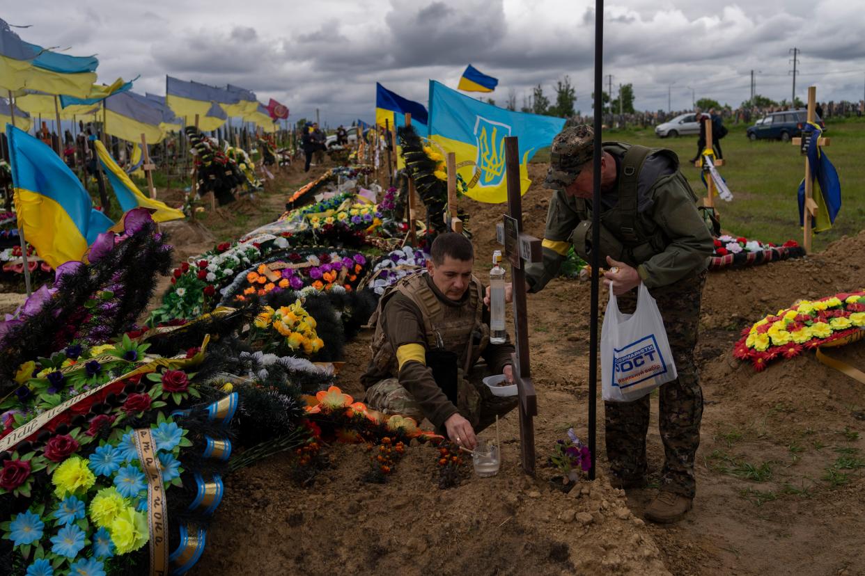 National guards visit the grave of a late soldier in Kharkiv cemetery, eastern Ukraine, Sunday, May 22, 2022. 