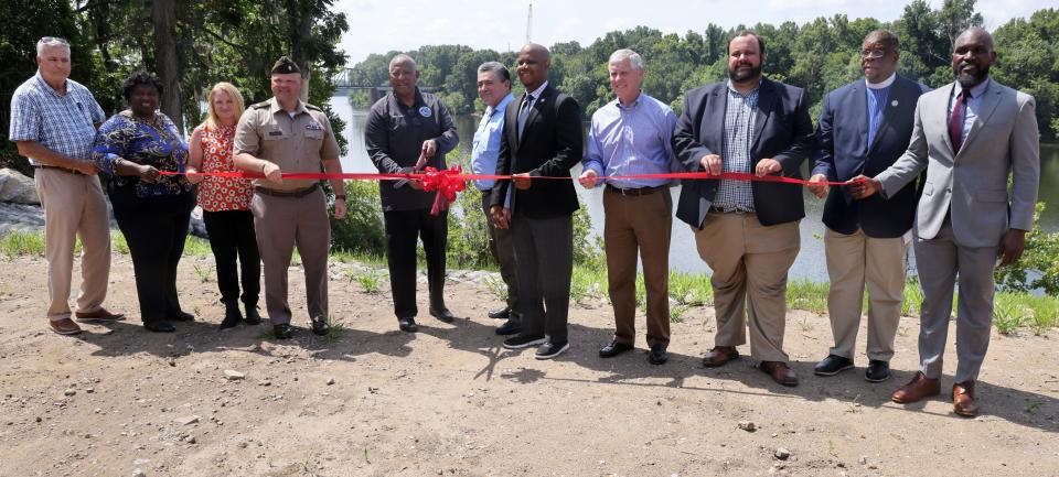 City of Selma Mayor James Perkins, Jr., center, cuts the ribbon while other dignitaries join in during the ribbon-cutting ceremony for Project 14 in Selma, Alabama, July 8, 2024. Project 14 was completed by the U.S. Army Corps of Engineers, Mobile District, and stabilized the bank of the Alabama River behind the historic train depot in Selma.