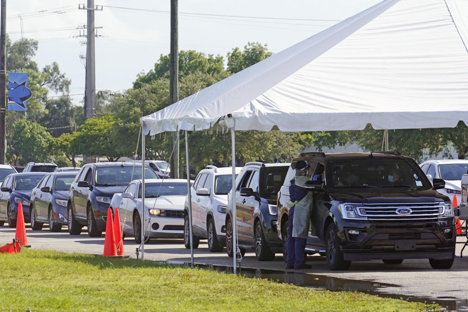 Cars line up at Miami Dade College North campus' COVID-19 testing site, Thursday, July 29, 2021, in Miami. Hospital admissions of coronavirus patients continue to soar in Florida with at least two areas in the state surpassing previous peaks reached during last summer's surge. (AP Photo/Marta Lavandier)