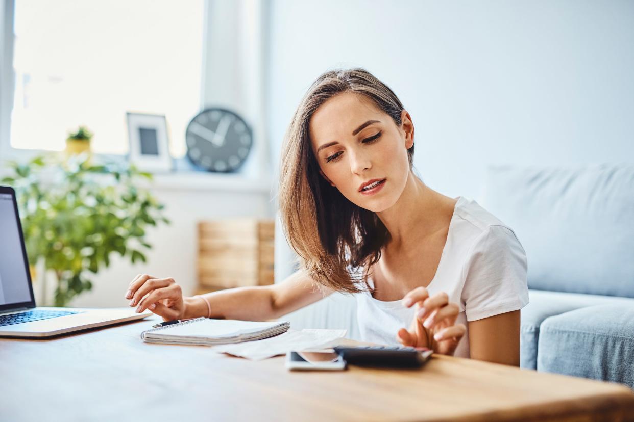 woman preparing home budget, using laptop and calculator