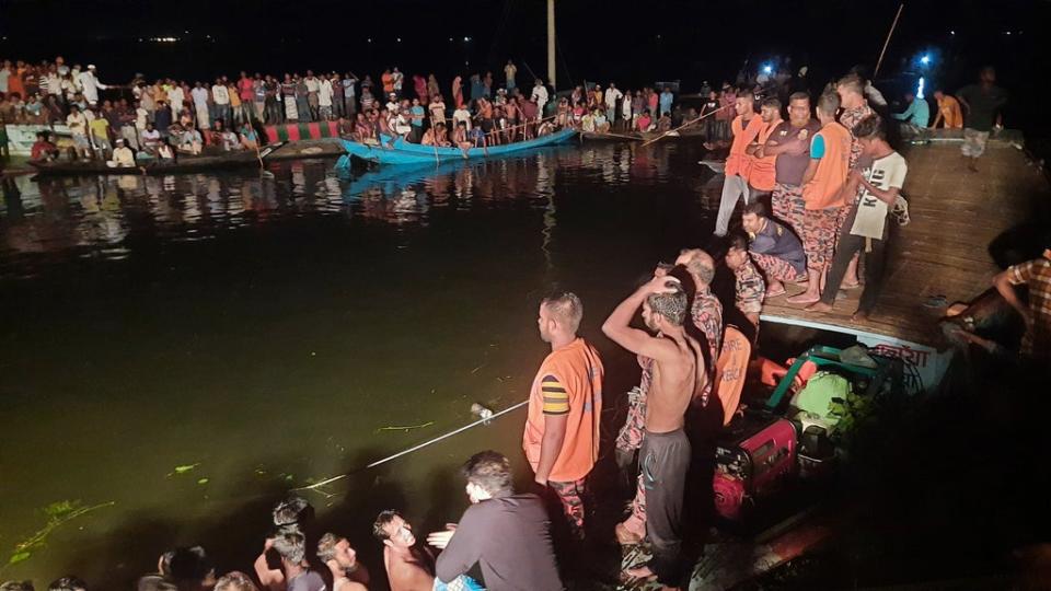 People watch rescue workers after a passenger boat sank in Brahmanbaria district, Bangladesh (AP)