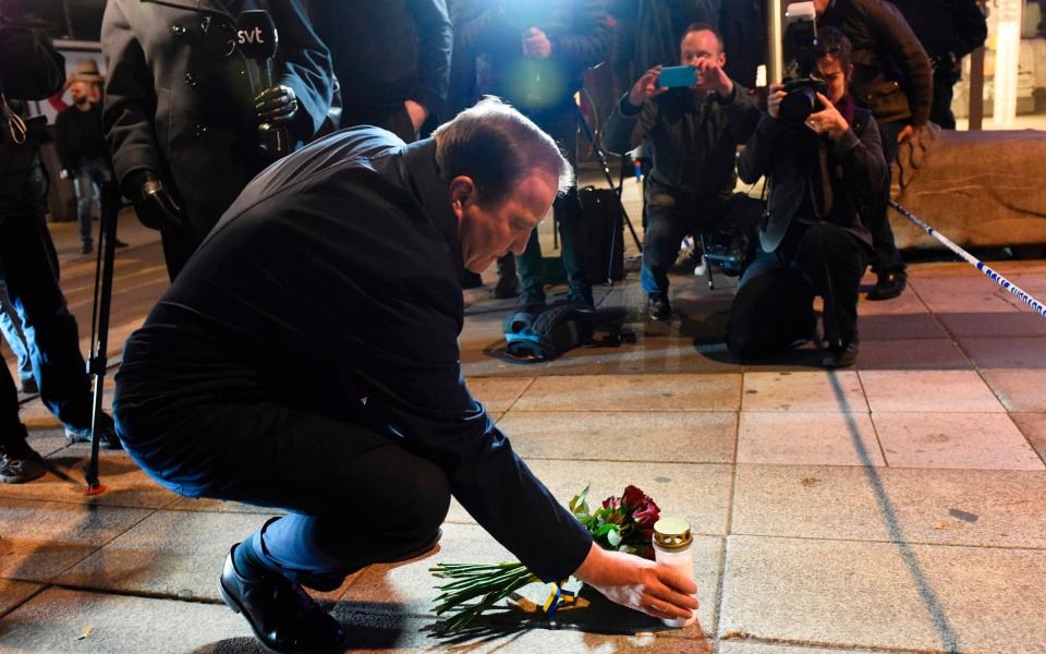 Swedish Prime Minister Stefan Lofven lays flowers and a candle at the scene  - Credit: Jonathan Nackstrand/AFP