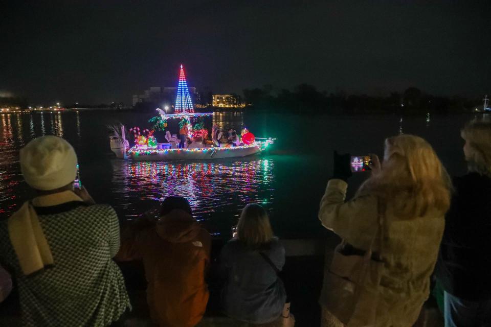 Onlookers take photos and video as the Savannah Boat Parade of Lights passes on Saturday, November 25, 2023.