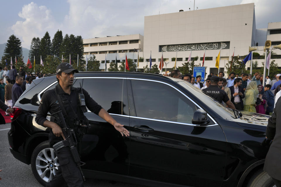 Security personnel secure the vehicle of Pakistan's Prime Minister Shehbaz Sharif as he leaves after a group photo with lawmakers of the National Assembly at the end of the last session of the current parliament, in Islamabad, Pakistan, Wednesday, Aug. 9, 2023. Pakistan's prime minister took a formal step Wednesday toward dissolving parliament, starting a possible countdown to a general election, as his chief political rival fought to overturn a corruption conviction that landed him in a high-security prison over the weekend. (AP Photo/Anjum Naveed)