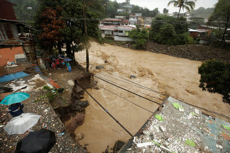 People look at a street collapsed by the Tiribi river flooded by heavy rains from Tropical Storm Nate in San Jose, Costa Rica October 5, 2017. REUTERS/Juan Carlos Ulate