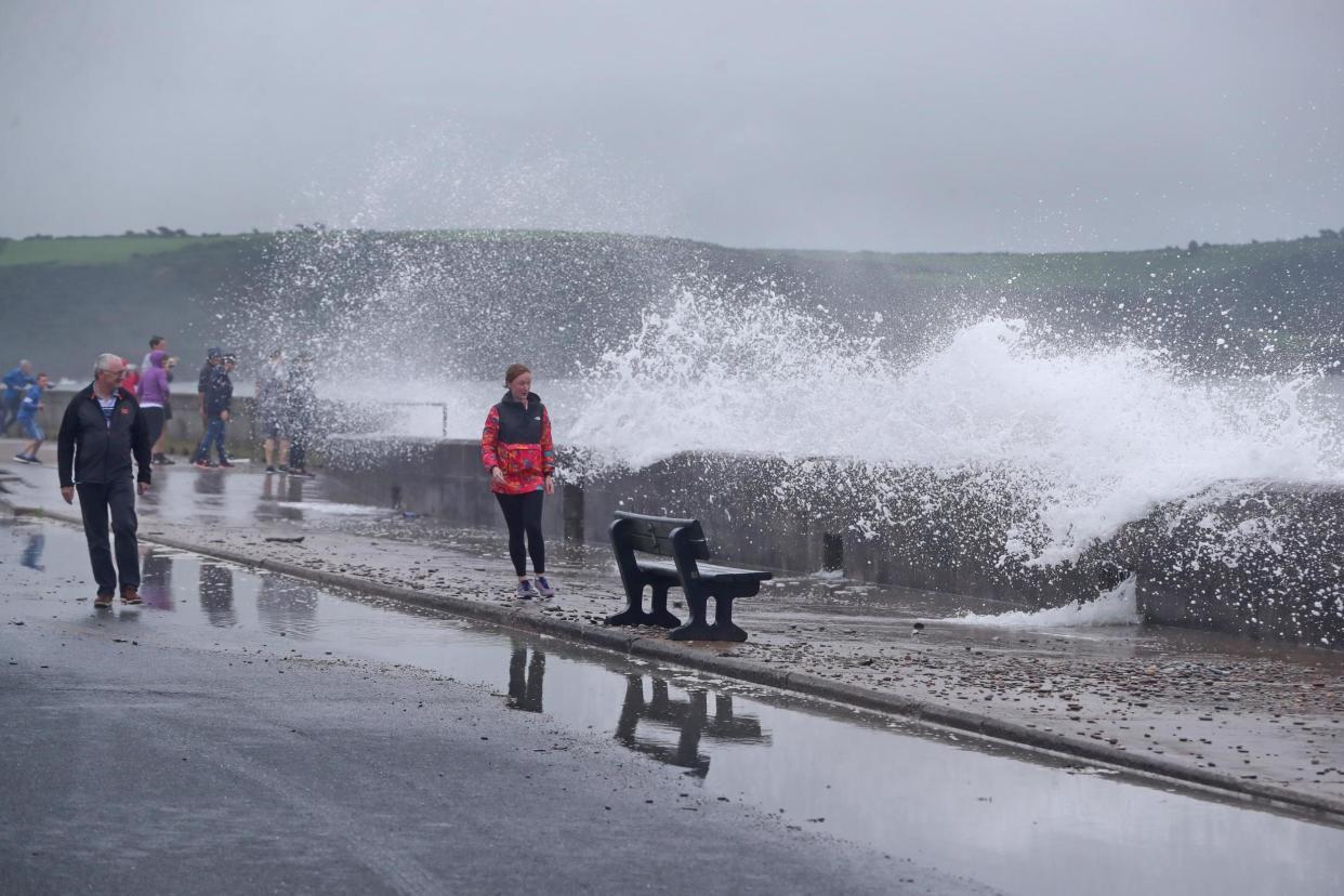 People try to avoid waves crashing on the Front Strand in Youghal, Co. Cork, Ireland as Storm Ellen sweeps across Ireland and the UK: PA