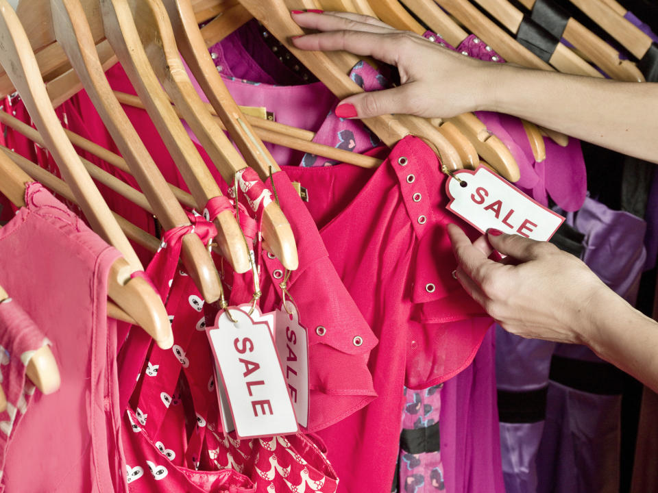 a rack of clothes with some marked on sale