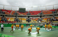 <p>Weil die Olympia-Tennisplätze in Rio de Janeiro nicht mit Planen abgedeckt werden konnten, musste der Regen notdürftig mit Handtüchern weggewischt werden. (Bild: Getty Images) </p>