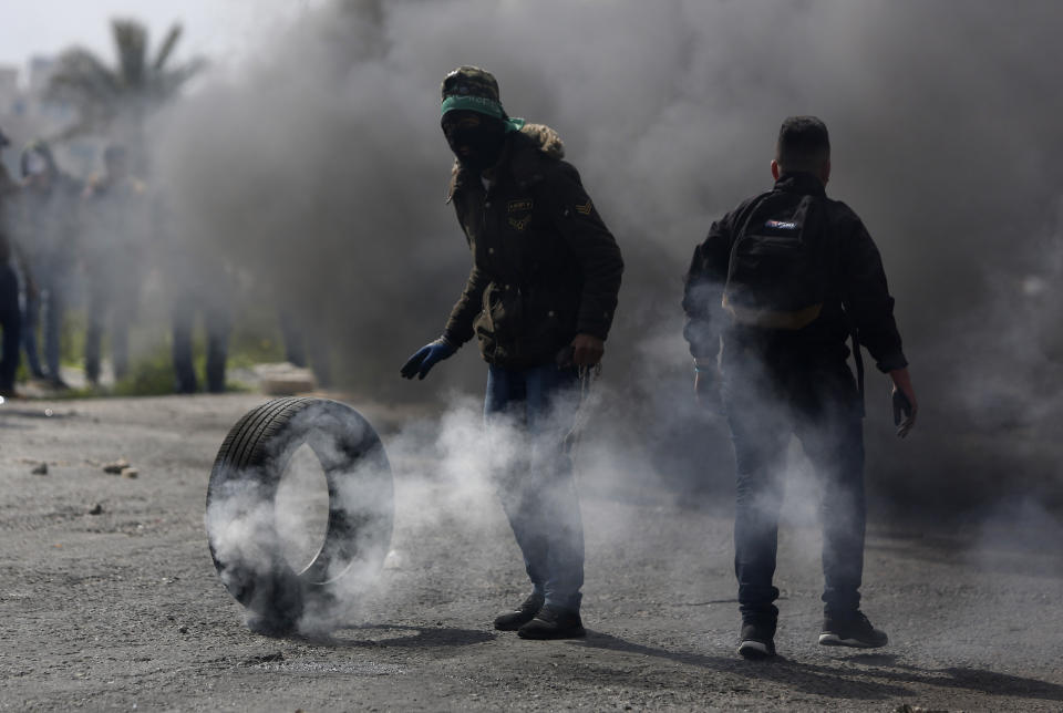 A Palestinian protester burns a tyre during a clashes with Israeli troops during demonstrators support of Palestinian prisoners held in Israeli jails at checkpoint Bet Eil near the West Bank city of Ramallah , Wednesday, March 27, 2019.(AP Photo/Majdi Mohammed)