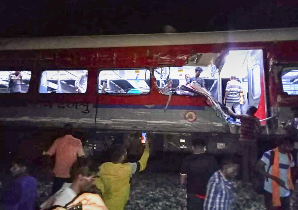 MANDATORY CREDIT- People inspect the site of passenger trains that derailed in Balasore district, in the eastern Indian state of Orissa, Friday, June 2, 2023. Two passenger trains derailed in India, killing at least 13 people and trapping hundreds of others inside more than a dozen damaged coaches, officials said. About 400 people were injured and taken to hospitals, and the cause of the accident was under investigation, officials said. (Press Trust of India via AP)