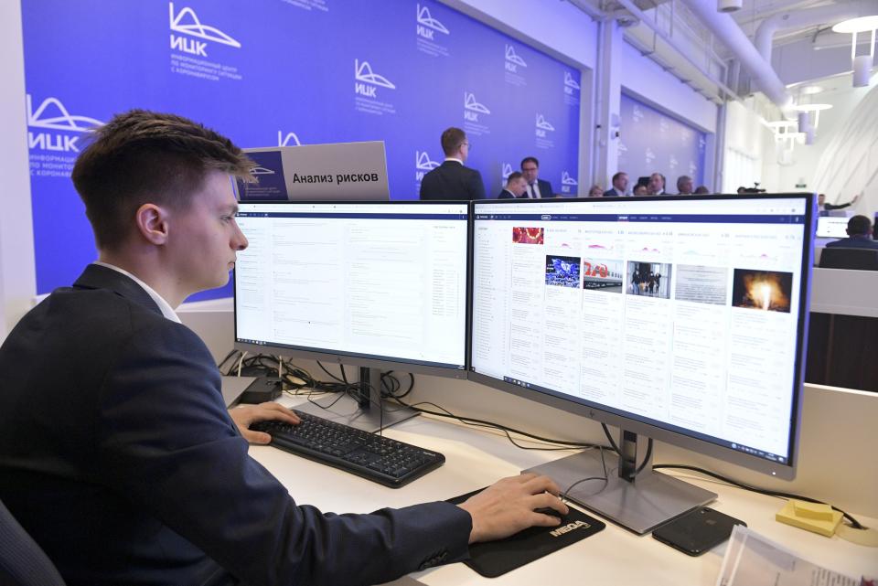 In this photo taken on Tuesday, March 17, 2020, An employee of a call center of the emergency response center on control and monitoring of the coronavirus disease, in Moscow, Russia. Russian authorities declared a war on "fake news" related to the new coronavirus. The crusade was triggered by what looked like a real disinformation campaign, but as the outbreak in Russia picked up speed and criticism of the Kremlin's "it is under control" stance mounted, the authorities cracked down on social media users doubting the official numbers and news outlets questioning the government's response to the epidemic. (Alexander Astafyev, Sputnik, Kremlin Pool Photo via AP)