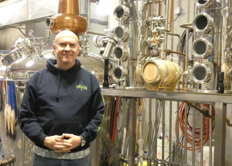 John Bassett, one of the co-owners of Iron Vault Distillery in Galion, stands in front of the still.