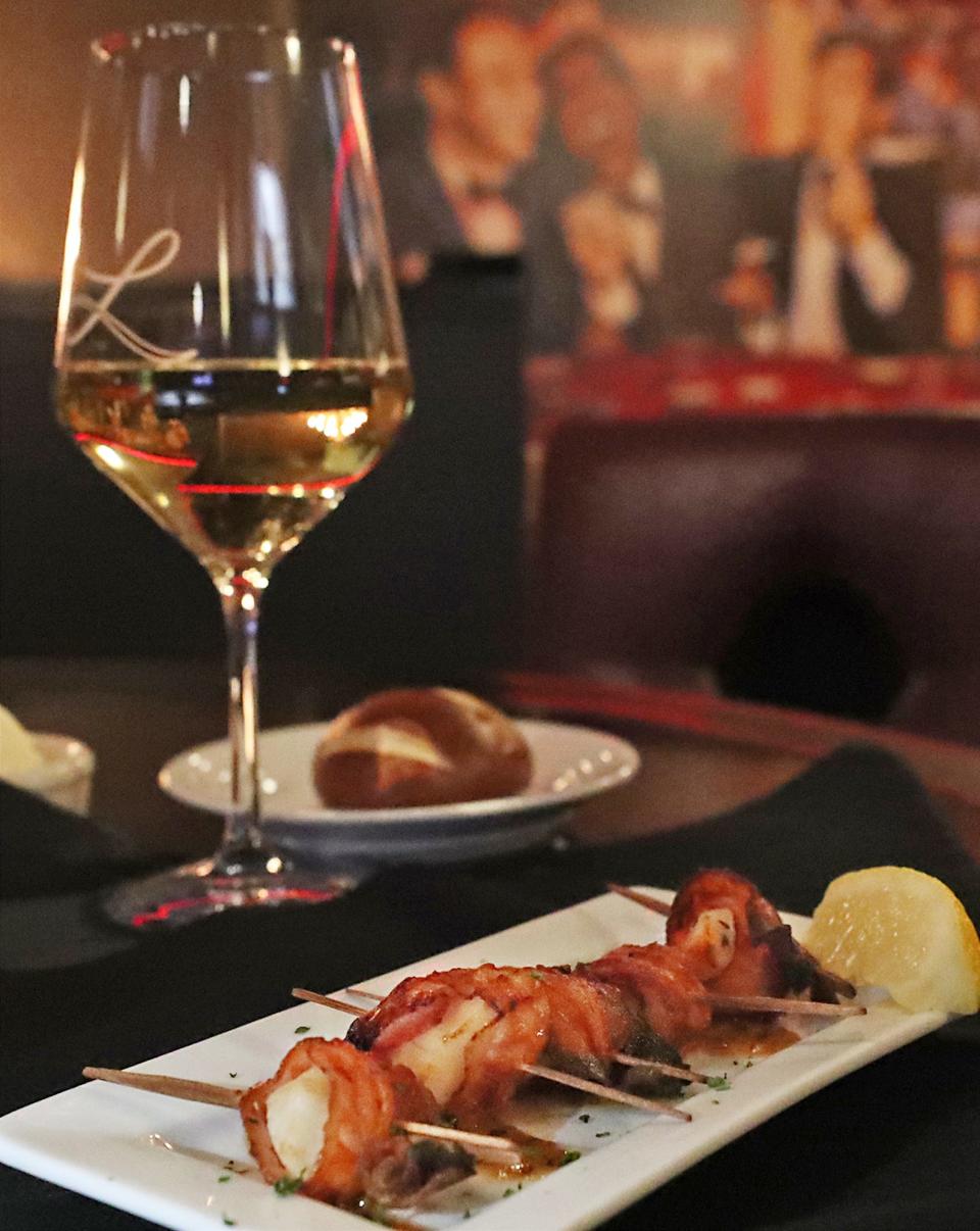 Bacon Wrapped Scallops and a glass of Chardonnay accompanied by a pretzel roll during Happy Hour in Deano’s Lounge at Dean Martin's Lanning's on Tuesday, Feb. 6, 2024 in Akron.