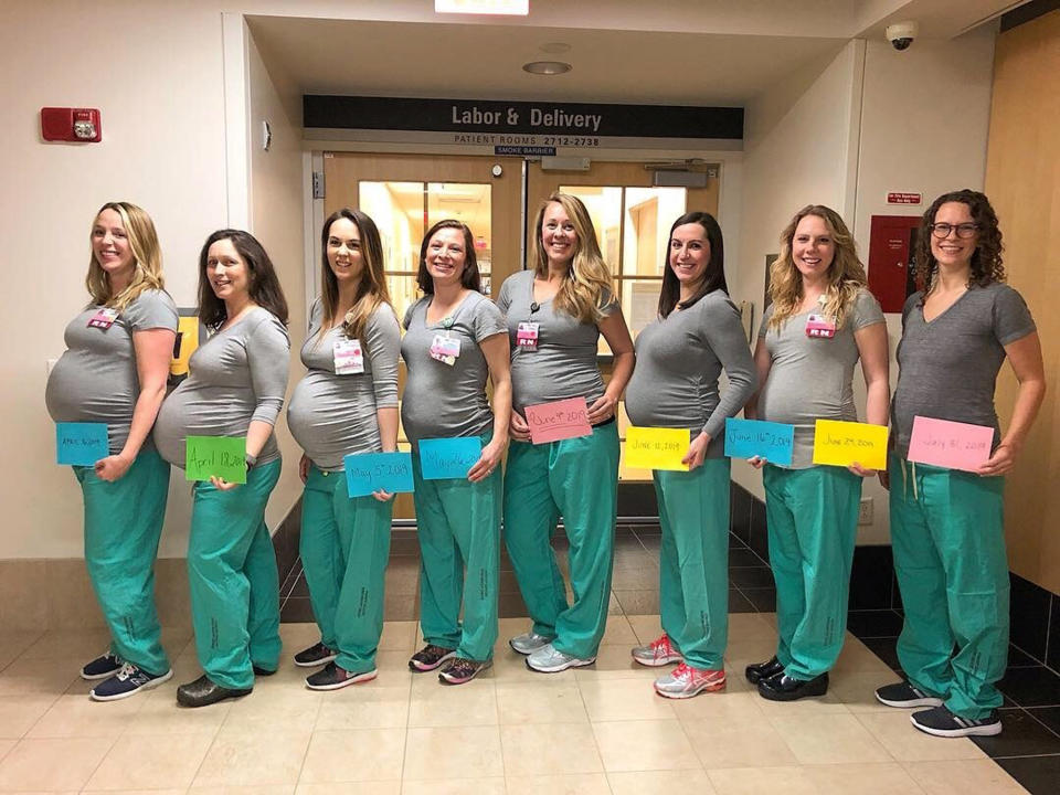 CORRECTS NAME TO BRITTNEY VERVILLE- In this March 23, 2019 photo, eight labor and delivery nurses at Maine Medical Center hold up cards with their due dates in Portland, Maine. Nine nurses at the Portland hospital’s labor and delivery unit are pregnant. The pictured nurses, from left to right, are Erin Grenier, Rachel Stellmach, Brittney Verville, Lonnie Souci, Amanda Spear, Samantha Giglio, Nicole Barnes and Holly Selby. Nicole Goldberg is not pictured. (Alicia Wilson/Maine Medical Center via AP)